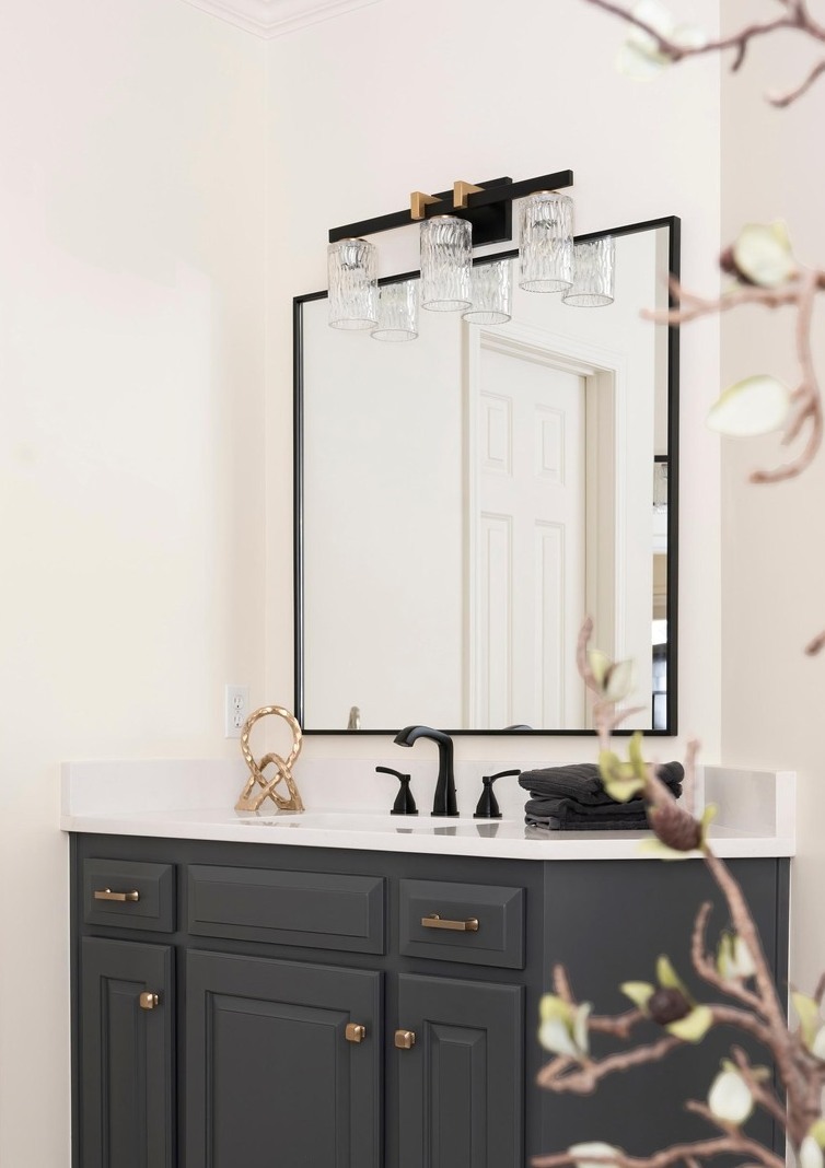 Modern primary bathroom with dark grey vanity, large rectangular mirror, and white marble countertops